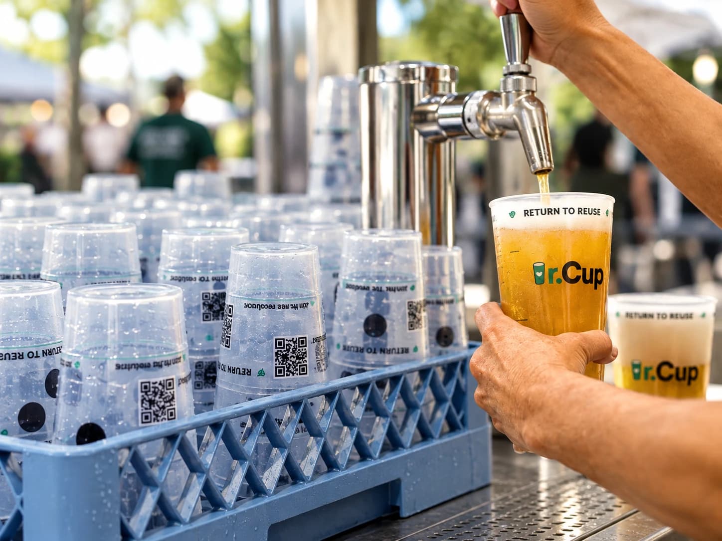 A reusable r.Cup being filled from a tap, stacked in a rack of return-to-reuse cups